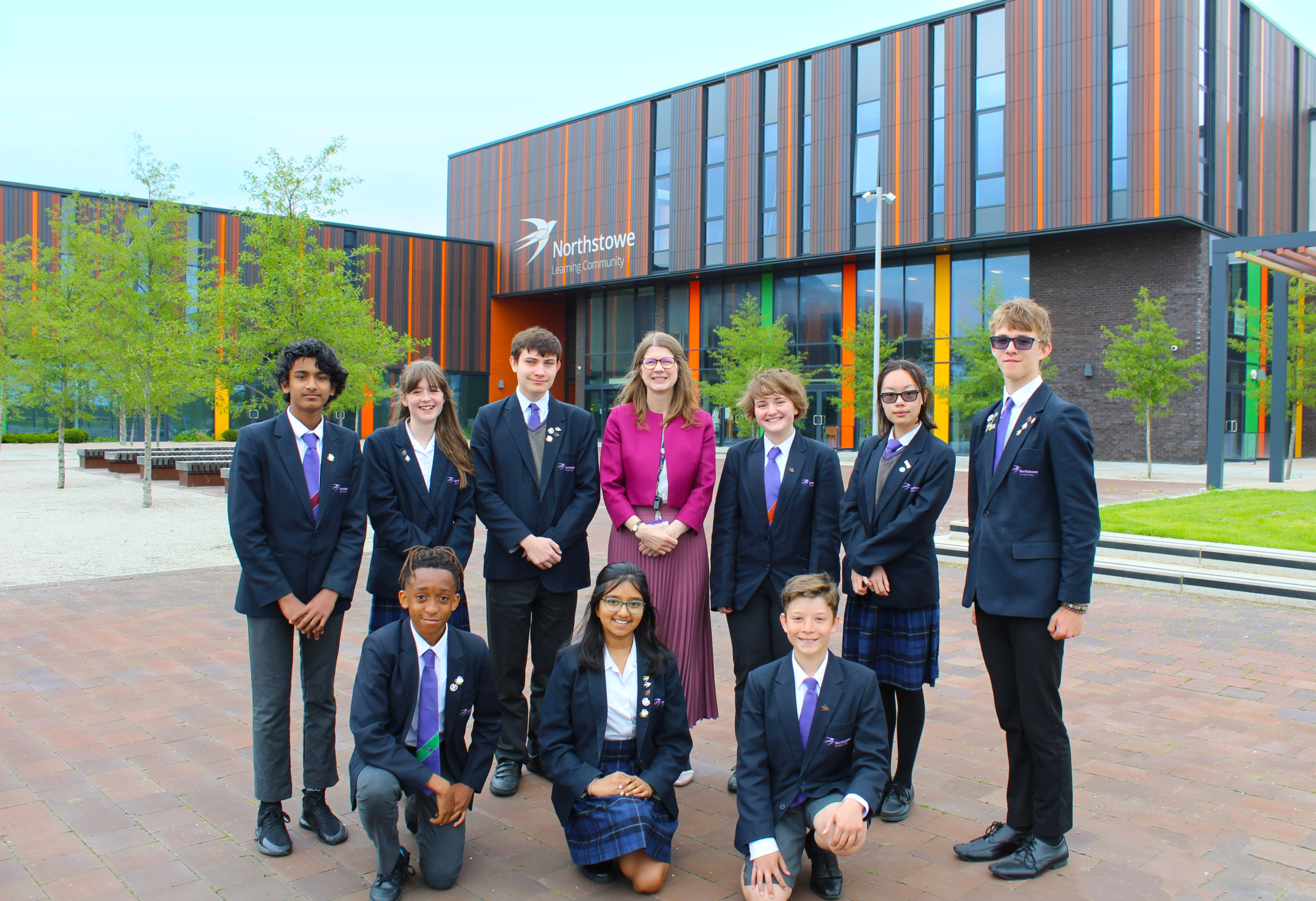 A photo of Headteacher Carole Moss and several students outside Northstowe Secondary College.